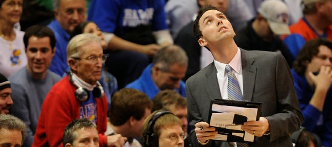 Former Jayhawk guard and current director of basketball operations Brett Ballard checks the scoreboard during a timeout in this Dec. 20 file photo from Allen Fieldhouse. After Ballard graduated in 2003, he began his career on KUs staff as a volunteer. Now, hes director of basketball operations for coach Bill Self.
